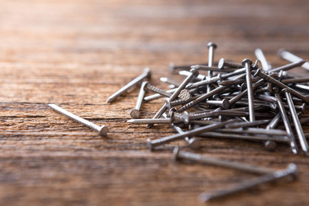Selective focus of Steel nails on wooden background with sunlight