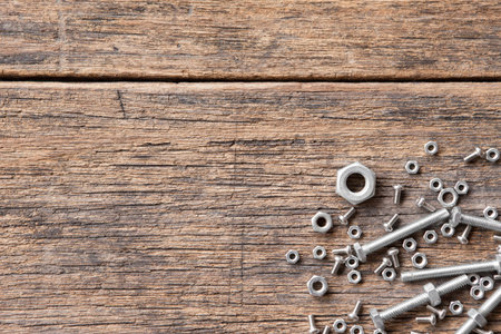 Top view of Many nuts and bolts on wood background and copy space