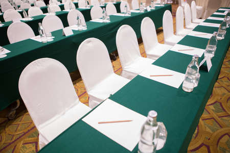 Paper, pencil, water bottle, glass on the table in the seminar room backgroundの写真素材