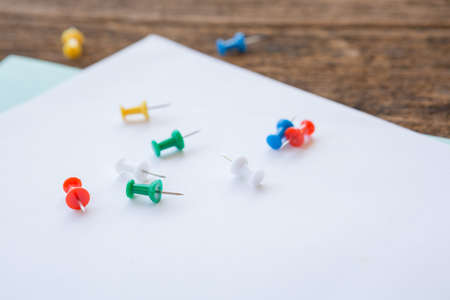 Selective focus of Colorful Many pins on notepad paper on wood board backgroundの写真素材