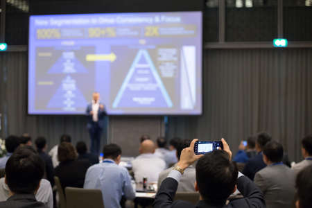 Attendees use smartphone photography in the seminar roomの写真素材