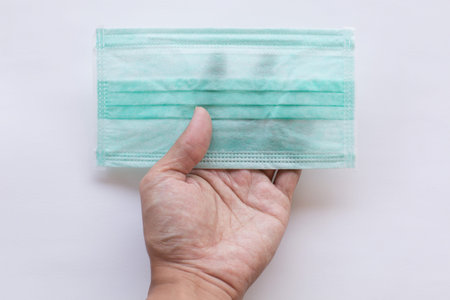 Isolated of hand holding Hygienic mask on white background
