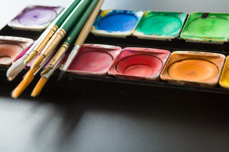 Colorful of Watercolor palette and paintbrush on a black background