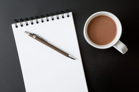 Notebooks , pen , coffee cup on black background