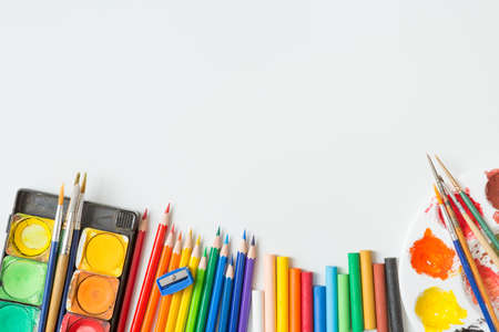 Top view of Colorful Watercolor palette, paintbrush, colored pencils, ruler and drawing equipment on white background and copy spaceの写真素材
