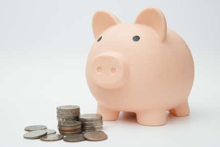 Piggy bank and Stack of coins on white backgroundの写真素材
