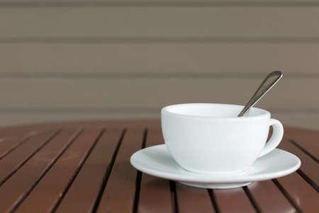 Selective focus of white coffee cup on the table in cafe blurred backgroundの写真素材