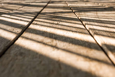 Selective focus of Pattern Beautiful light and shadow on the wooden floor texture backgroundの写真素材