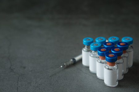 Selective focus of Many vaccine bottles and syringes on concrete background for virus concept and...