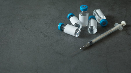 Many vaccine bottles and syringes on concrete background for virus  concept and copy space