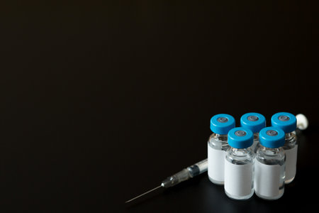 Selective focus of Many vaccine bottles and syringes on black background for virus  concept and copy spaceの写真素材
