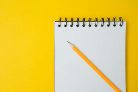 Top view of Notebook, pencil on a yellow background and copy spaceの写真素材