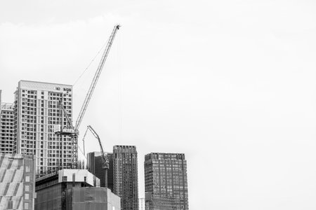 Black and white of Crane on the building under construction on blue sky and cloud backgroundの写真素材