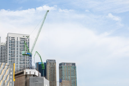 Crane on the building under construction on blue sky and cloud backgroundの写真素材