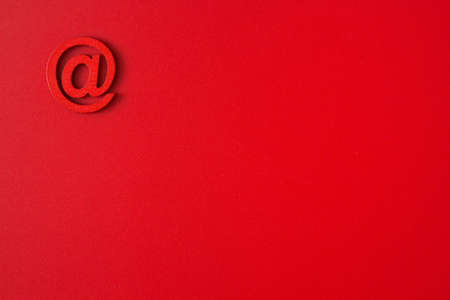 Red wooden symbol "at" on red background and copy space for social media educational conceptの写真素材