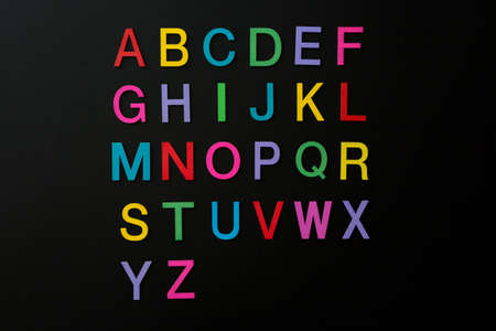 Colorful wooden english letters A-Z on black background and copy space for educational and graphic conceptの写真素材