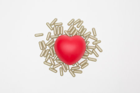 Heart shaped squeeze ball and pill capsule on white background and copy space for health care conceptの写真素材