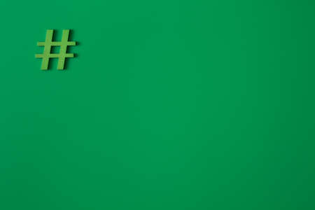 Green wooden symbol Hashtag "#" on green background and copy space for social media educational conceptの写真素材