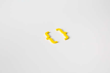 Yellow wooden symbol "bracket" on white background and copy space for social media educational conceptの写真素材