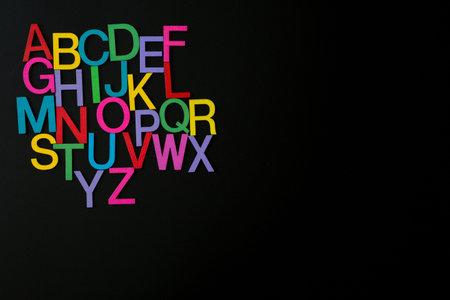 Colorful wooden english letters A-Z on black background and copy space for educational and graphic conceptの写真素材