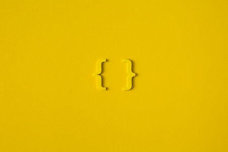 Yellow wooden symbol "bracket" on yellow background and copy space for social media educational conceptの写真素材