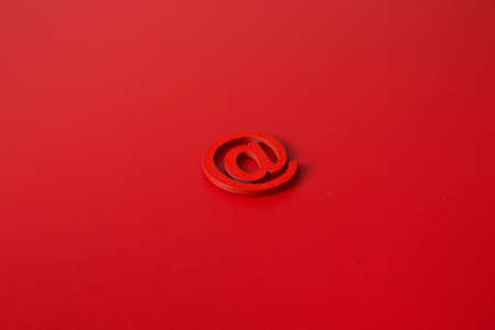 Red wooden symbol "at" on red background and copy space for social media educational conceptの写真素材