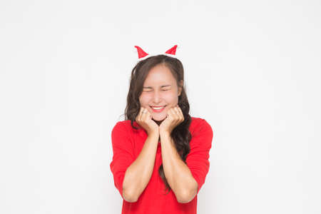 Beautiful Asian woman wearing small Santa hat and wearing red dress on white background. Cute Asian woman cheerful and scream on Christmas and New Year's Day.の写真素材