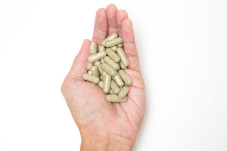 Selective focus of Many medicine capsules on hand on white background and copy space for health care...