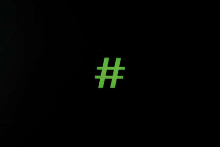 Green wooden symbol Hashtag "#" on blsck background and copy space for social media educational conceptの写真素材