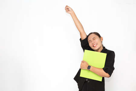 Beautiful Asian business woman wearing black suit holding document folder and happy with success something on white background and copy space. Confident Asian working woman smiling and cheerfulの写真素材