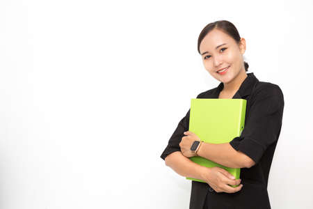 Beautiful Asian business woman wearing black suit holding document folder smiling on white background and copy space. Confident Asian working woman smiling and cheerfulの写真素材