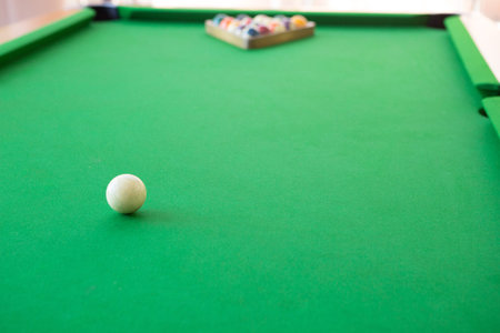 Selective focus of Colorful pool balls on green pool table.