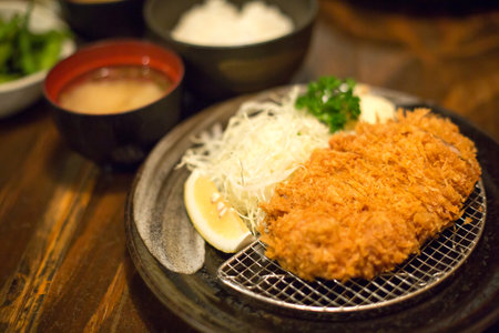 Selective focus of Tonkatsu set on wooden table in Japanese restaurant.の写真素材