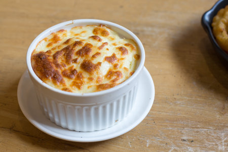 Cheese mashed potatoes in white cup on the wood table in restaurant.の写真素材