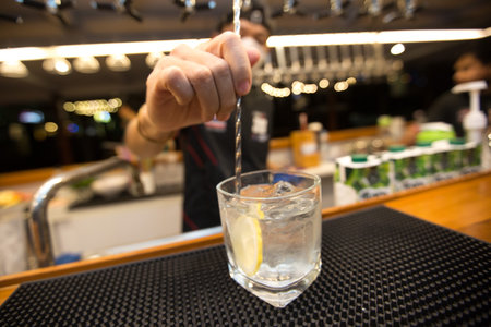Bartender mixing cocktails for customers on bar counter.の写真素材
