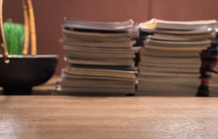 focus on wooden table with book  and magazine stack arrangement blurred backgroundの写真素材