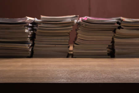focus on wooden table with book  and magazine stack arrangement blurred backgroundの写真素材