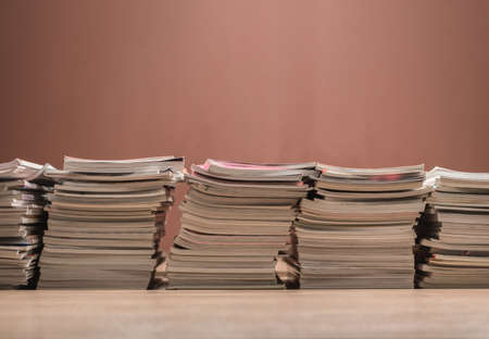 book and magazine stack arrangement background on wooden table for readの写真素材