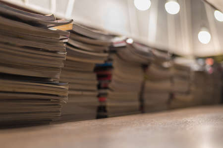 focus on book and magazine stack arrangement background on wooden table for readの写真素材
