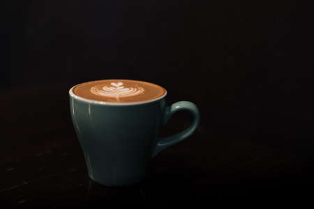 ceramic cup of hot coffee with latte art  in low-key lightingの写真素材
