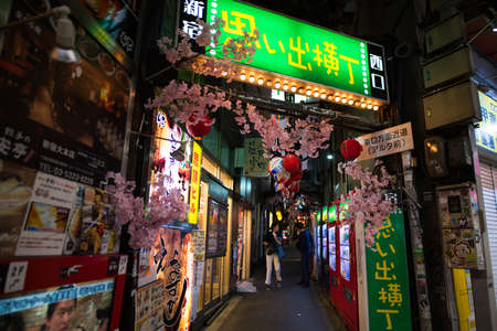 Tokyo, Japan - April 3 , 2018 : Famous place Japanese local steet food at Omoide Yokocho, Shinjuku tokyo in spring season , decorated with sakura cherry blossom very beautiful sceneのeditorial素材