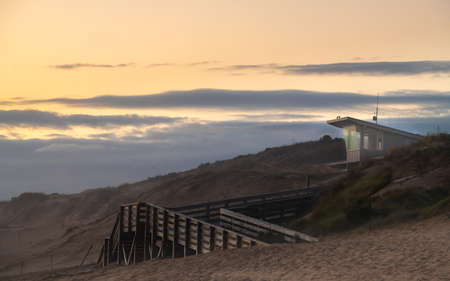 beautiful beach house with wooden bridge and radio communication post , grass on hillの写真素材