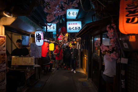 Tokyo, Japan - April 3 , 2018 : Famous place Japanese local street food at Omoide Yokocho, Shinjuku tokyo in spring season, decorated with sakura cherry blossom very beautiful sceneのeditorial素材