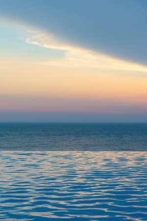 infinity swimming pool with twilight sky and ocean background ,good time for relaxの写真素材