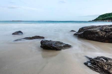 The soft wave swash the rock on the beachの写真素材