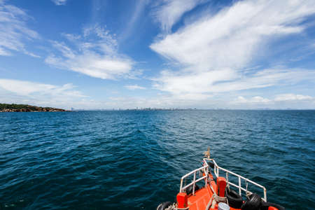 The boat in the sea go to the city in sunny dayの写真素材