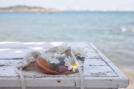 Net flower bag on the table near the seaの写真素材