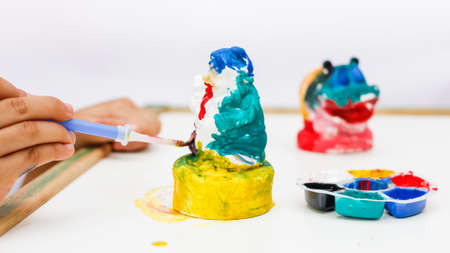 The kid painting color on the plaster statueの写真素材