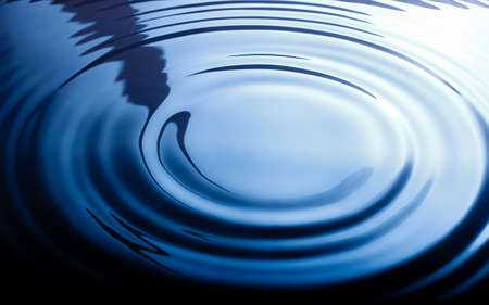 The wave from water drop in blue backgroundの写真素材