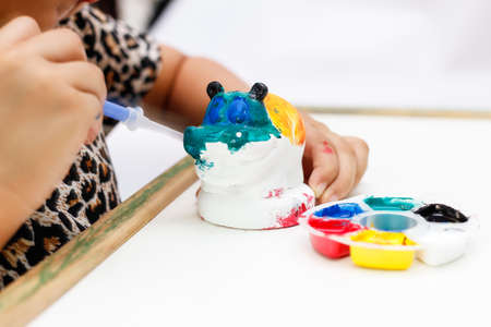 The kid painting color on the plaster statueの写真素材